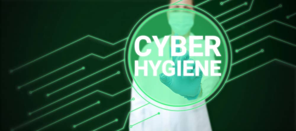 Persona con bata y guante de laboratorio señalando el texto 'Cyber Hygiene' sobre un fondo tecnológico de color verde.