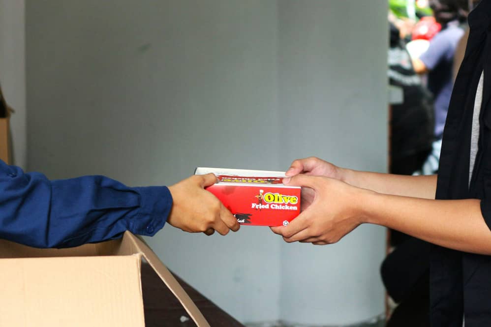 Ventajas de vender con pago contra entrega en tu negocio 20 Intercambio de paquete entre manos, ilustrando la facilidad del pago contra entrega en tu negocio.